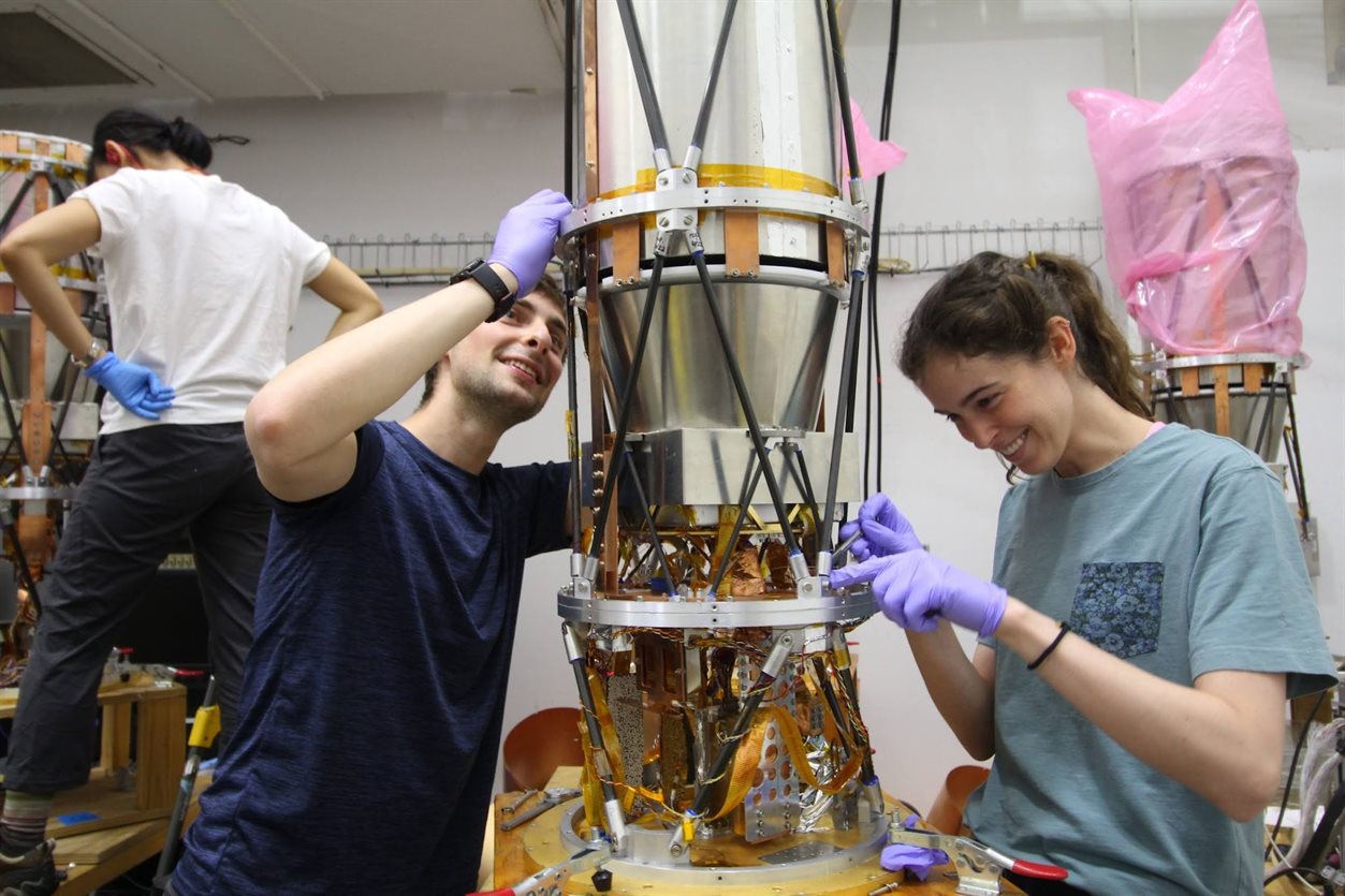 Illinois Physics graduate student Elle Shaw (right) replaces some carbon fiber truss legs on one of the six telescopes. Each telescope must be carefully inspected before loading it into the cryostat.